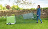 A person moving a chicken coop with a run using handles