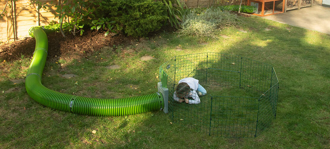 Kid playing in Omlet rabbit Zippi playpen with Omlet Zippi tunnel