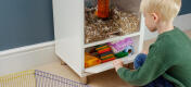 Young boy storing his hamster bedding, toys and accessories in the storage compartment.