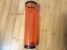A orange Qute tube for a hamster or gerbil cage