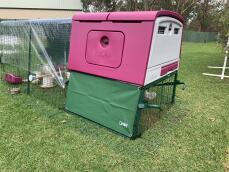 A large purple Cube chicken coop with a run attached with covers on top