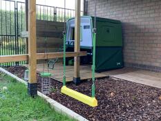 Chicken swing outside a Cube chicken coop in a garden with lots of Omlet products