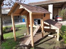 Omlet grey automatic chicken coop door attached to wooden chicken coop