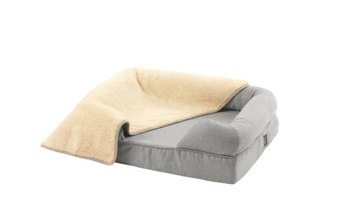 Grey small 24 memory foam bolster bed with a cream plush blanket over the top