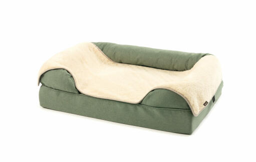 Plush grey and fur blanket on a green bolster bed 36