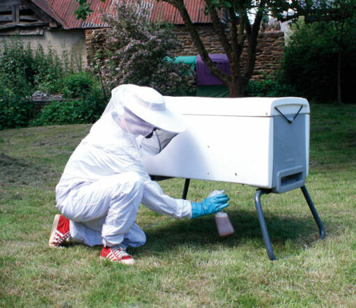 A white Beehaus beehive with liquid smooker being used.