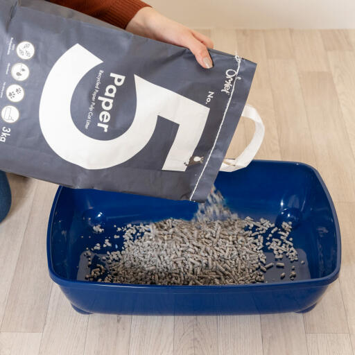 Pouring Omlet paper cat litter into litter tray