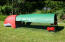 Red Eglu Classic chicken coop with run and full length green cover providing shade in the garden