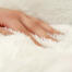 A women stroking a soft cat bed.