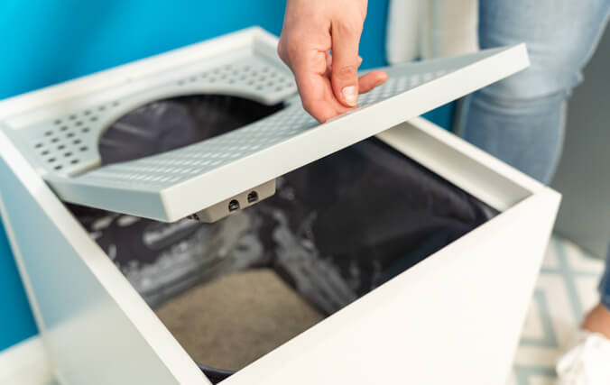 hand lifting the lid of the maya cat litter box furniture