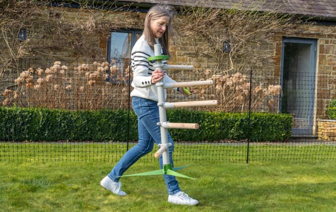 Woman easily moving the free standing chicken perch tree